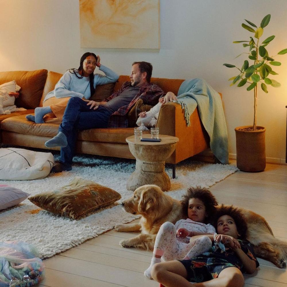 Family in a living room, part of the Infinity Thermostat campaign.